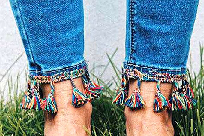 Cropped jeans with coloured tassels along the hems