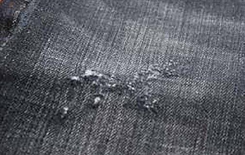 Close-up of grey washed denim with small abrasions
